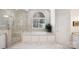 Bright and airy bathroom featuring a soaking tub, a separate shower, and marble tile at 6403 Amos Smith Rd, Charlotte, NC 28214