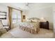 Comfortable bedroom with floral bedding, ceiling fan, and charming striped curtains at 6403 Amos Smith Rd, Charlotte, NC 28214