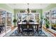 Dining room with many windows offering lake views, chandelier and a large area rug at 6403 Amos Smith Rd, Charlotte, NC 28214