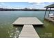 Wooden dock featuring direct water access with a large floating platform and an adjacent covered boat lift at 6403 Amos Smith Rd, Charlotte, NC 28214