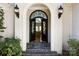 Elegant front entrance featuring decorative iron doors, stone steps, and stylish outdoor lighting fixtures at 6403 Amos Smith Rd, Charlotte, NC 28214