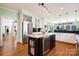 Gourmet kitchen featuring an island with a wine fridge, stainless steel appliances, and wood floors at 6403 Amos Smith Rd, Charlotte, NC 28214