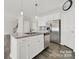 Modern kitchen island featuring granite countertops, stainless steel appliances, and white cabinets at 769 River Park Rd, Belmont, NC 28012