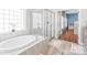 Bright bathroom featuring an oval soaking tub and glass-enclosed shower at 8504 Soaring Eagle Ln, Waxhaw, NC 28173