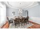 Elegant dining room featuring tray ceiling, wainscoting, and a large table set for eight at 8504 Soaring Eagle Ln, Waxhaw, NC 28173