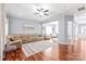 Bright living room featuring hardwood floors, large windows, and comfortable sectional sofa at 8504 Soaring Eagle Ln, Waxhaw, NC 28173