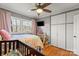 Cozy bedroom with light pink accents, wood floors, and natural light from the large window overlooking trees at 910 Forest Dr # 14, Lancaster, SC 29720