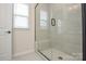 Modern bathroom featuring a tiled shower with glass enclosure and bench seat at 1028 Grays Mill Rd, Charlotte, NC 28215
