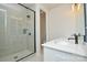 Bathroom featuring a dual sink vanity and walk-in shower with tile surround at 1028 Grays Mill Rd, Charlotte, NC 28215