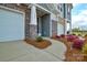 Charming townhome exterior featuring a walkway, rock facade, two garage doors, and a well-maintained landscaped yard at 1028 Grays Mill Rd, Charlotte, NC 28215