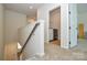 Upstairs hallway with carpet flooring, a wooden handrail, and a laundry room with a washer and dryer at 1028 Grays Mill Rd, Charlotte, NC 28215