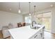Open kitchen features a large island with sink, pendant lighting, dining area, sliding glass doors, and couch view at 1028 Grays Mill Rd, Charlotte, NC 28215