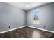 Neutral bedroom with hardwood floors, gray walls, white trim, and a window overlooking the backyard at 105 4Th Se St, Catawba, NC 28609