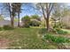 A spacious backyard with various bushes, plants and flowerbeds around the perimeter with mature trees providing shade at 10633 Hwy 52 Hwy, Rockwell, NC 28138