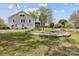 View of home's backyard with lush lawn, flowerbeds, and a detached garage at 10633 Hwy 52 Hwy, Rockwell, NC 28138