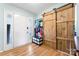 Bright foyer featuring wood flooring, a white front door with glass accents, and a rustic sliding barn door at 11416 Leadenhall Ln # 22, Charlotte, NC 28262