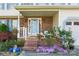 Inviting front porch with brick accents, a variety of foliage and flowers, and seating for guests at 11416 Leadenhall Ln # 22, Charlotte, NC 28262