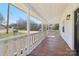 Relaxing front porch with stained wood flooring and white railings offer a cozy outdoor space at 1156 9Th St, Lancaster, SC 29720