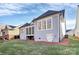 Exterior view of a home with light-blue vinyl siding and large windows overlooking a lush green lawn at 1157 Bunch Dr, Statesville, NC 28677