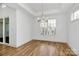 Dining room features a modern chandelier, natural light, tray ceilings and hardwood floors at 1157 Bunch Dr, Statesville, NC 28677