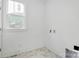 Charming laundry room features elegant marble-look tile flooring and a window providing natural light at 1157 Bunch Dr, Statesville, NC 28677