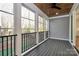 View of enclosed porch featuring wood ceiling, ceiling fan, gray vinyl siding and black metal railings at 1157 Bunch Dr, Statesville, NC 28677