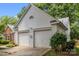 Spacious two-car garage with white doors, set against a backdrop of mature trees at 1286 Saint Katherines Way, Rock Hill, SC 29732