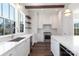 Modern kitchen featuring white cabinets, marble countertops, stainless steel appliances, and hardwood floors at 3115 Pinehurst Pl, Charlotte, NC 28209