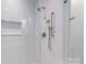 Modern shower boasts herringbone-patterned tiles, rainfall showerhead, and glass enclosure at 3115 Pinehurst Pl, Charlotte, NC 28209