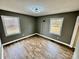 Bedroom featuring laminate floors, neutral walls, and two bright windows with views of outdoors at 132 Pisgah Church Rd, Statesville, NC 28625
