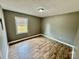Bedroom featuring laminate wood flooring, neutral walls, and a bright window at 132 Pisgah Church Rd, Statesville, NC 28625