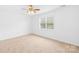 Bright bedroom features neutral carpet, ceiling fan, and natural light at 13705 Queenswater Ln, Charlotte, NC 28273