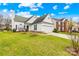 Charming white home featuring a well-manicured lawn, attached garage and lush landscaping at 13705 Queenswater Ln, Charlotte, NC 28273