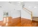 Bright living room showing hardwood floors, stairs and a view into dining area at 13705 Queenswater Ln, Charlotte, NC 28273
