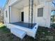 Inviting front porch with white brick and black iron accents, perfect for relaxing outdoors at 1408 Linwood Rd, Gastonia, NC 28052