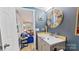 Bathroom vanity with round mirror and decor in a modern home at 162 Dogwood Cir, New London, NC 28127