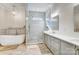 A luxurious bathroom featuring a soaking tub, glass-enclosed shower, and double vanity with modern finishes at 215 Wesley Manor Dr, Matthews, NC 28104