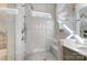 A spacious, tiled shower with built-in bench, sleek fixtures, window and glass surround in a contemporary bathroom at 215 Wesley Manor Dr, Matthews, NC 28104