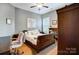 This bedroom boasts a wood-framed bed, hardwood floors, ceiling fan, and bright natural light at 215 Wesley Manor Dr, Matthews, NC 28104