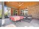 Covered patio features a brick wall, wood ceiling, sliding glass door, and an outdoor dining set at 215 Wesley Manor Dr, Matthews, NC 28104