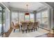 Bright dining room featuring large windows, stylish chandelier, and elegant furnishings at 215 Wesley Manor Dr, Matthews, NC 28104