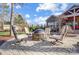 A paver patio with a stone fire pit and four cushioned chairs at 215 Wesley Manor Dr, Matthews, NC 28104