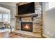 Stunning stone fireplace with a wooden mantle and mounted television enhances the living space at 215 Wesley Manor Dr, Matthews, NC 28104