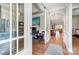 Inviting hallway with hardwood floors, leading to an office and open-concept living space at 215 Wesley Manor Dr, Matthews, NC 28104