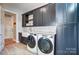 A well-appointed laundry room featuring modern appliances, ample storage, and a convenient sink area at 215 Wesley Manor Dr, Matthews, NC 28104