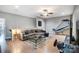 A spacious living room features a large couch, hardwood floors, and a gaming setup at 215 Wesley Manor Dr, Matthews, NC 28104