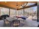 This covered patio contains a large table, ceiling fan, and is surrounded by the woods at 215 Wesley Manor Dr, Matthews, NC 28104
