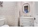 Stylish powder room features patterned wallpaper, a marble countertop vanity, and modern fixtures at 215 Wesley Manor Dr, Matthews, NC 28104