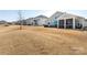 Spacious backyard showcasing a manicured lawn, screened-in patio, and neighboring homes at 2296 Idol Rock Dr, Indian Land, SC 29707