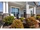 Inviting front porch featuring stone columns, outdoor seating, and lush landscaping, creating a cozy entrance at 2296 Idol Rock Dr, Indian Land, SC 29707